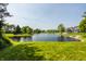 Scenic view of a serene pond surrounded by lush greenery and beautiful homes at 1229 Helford Ln, Carmel, IN 46032