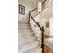Carpeted staircase with white railing, dark trim, and decorative lighting at 1229 Helford Ln, Carmel, IN 46032