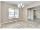 Bright dining room with wood floors, a modern chandelier, and a large window at 12679 Chargers Ct, Fishers, IN 46037