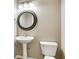Neat powder room featuring a pedestal sink, decorative mirror, and tiled flooring at 12679 Chargers Ct, Fishers, IN 46037