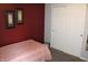 Cozy bedroom with a red accent wall, a black metal bed frame, and white closet doors at 12901 N Collett Way, Camby, IN 46113