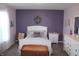 Inviting bedroom with lilac walls, soft carpet, and a plush white bed with a wreath on the wall at 12901 N Collett Way, Camby, IN 46113