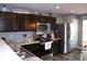 Efficient kitchen with stainless steel appliances, dark wood cabinets, and well-lit countertops, great for cooking at 12901 N Collett Way, Camby, IN 46113