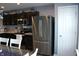 Modern kitchen featuring stainless steel refrigerator, dark cabinets, and functional layout, ready for culinary adventures at 12901 N Collett Way, Camby, IN 46113