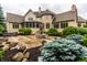 A landscaped backyard features a stone patio, outdoor dining, and a hot tub at 13346 W Sherbern Dr, Carmel, IN 46032