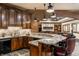 Basement bar with stone countertops, wood cabinets, brick accent, undermount sink, and unique lighting at 13346 W Sherbern Dr, Carmel, IN 46032