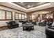 Spacious basement area with elegant leather chairs, fireplace, and exposed brick accent wall at 13346 W Sherbern Dr, Carmel, IN 46032