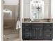 Bathroom with a glass shower, dark cabinets, and decorative vanity lights at 13346 W Sherbern Dr, Carmel, IN 46032