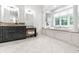 Bright bathroom featuring a soaking tub with jets, tiled floor, and -and- vanity at 13346 W Sherbern Dr, Carmel, IN 46032