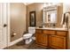 Neutral half bathroom featuring vanity with storage, framed mirror, and a decorative light fixture at 13346 W Sherbern Dr, Carmel, IN 46032