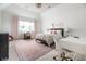 Bright bedroom featuring pink accents, carpet floors, two desk areas, and closet space at 13346 W Sherbern Dr, Carmel, IN 46032