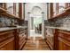Butler pantry with wooden cabinets, mosaic backsplash and hardwood floors at 13346 W Sherbern Dr, Carmel, IN 46032