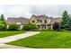 Elegant home with manicured front lawn and covered porch, perfect for outdoor enjoyment at 13346 W Sherbern Dr, Carmel, IN 46032