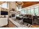 Spacious living room with stone fireplace, wood beam ceiling, and large windows at 13346 W Sherbern Dr, Carmel, IN 46032