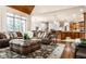 Open-concept living room features a plush sofa, leather ottoman, and natural light at 13346 W Sherbern Dr, Carmel, IN 46032