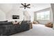 Living room with a large couch, neutral carpet, a ceiling fan, and a flat screen TV at 13346 W Sherbern Dr, Carmel, IN 46032