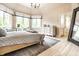 A light and spacious main bedroom featuring large windows, a desk, and a dresser at 13346 W Sherbern Dr, Carmel, IN 46032