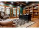 Executive home office with coffered ceilings, built-in bookshelves, and a large desk at 13346 W Sherbern Dr, Carmel, IN 46032