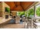 Comfortable covered outdoor kitchen with a brick fireplace, TV, and ample seating at 13346 W Sherbern Dr, Carmel, IN 46032