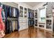 Large walk-in closet with custom shelving, hanging racks, and hardwood floors at 13346 W Sherbern Dr, Carmel, IN 46032