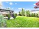 Lush backyard featuring a well-manicured lawn, stone pathway and a covered patio for relaxation and entertainment at 13844 N Cardonia Dr, Camby, IN 46113
