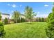 Lush green backyard with a manicured lawn, mature trees, and privacy fence at 13844 N Cardonia Dr, Camby, IN 46113