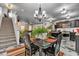 Open dining area with modern chandelier and a view of the adjacent kitchen and staircase at 13844 N Cardonia Dr, Camby, IN 46113