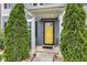 Inviting front entrance featuring a vibrant yellow door, white pillars, and meticulously manicured greenery at 13844 N Cardonia Dr, Camby, IN 46113