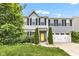 Charming two-story home with a well-manicured lawn, mature trees, and a welcoming yellow front door at 13844 N Cardonia Dr, Camby, IN 46113