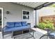 Relaxing covered patio with gray siding, blue cushioned seating and stylish outdoor rug at 13844 N Cardonia Dr, Camby, IN 46113