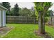 View of the backyard, showcasing the lawn, mature tree, and wooden privacy fence at 1411 Mimosa Ct, Greenfield, IN 46140
