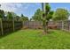 A partially fenced backyard with a mature tree on a clear, sunny day at 1411 Mimosa Ct, Greenfield, IN 46140
