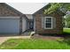 Brick house with a front door, green grass and an attached two-car garage at 1411 Mimosa Ct, Greenfield, IN 46140