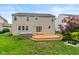 A backyard featuring a wooden deck, a hot tub, green lawn, and well-maintained landscaping for outdoor enjoyment at 14446 Chapelwood Ln, Fishers, IN 46037