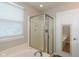 Bathtub with a glass door shower stall and a doorway to another room at 14446 Chapelwood Ln, Fishers, IN 46037