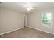 A carpeted bedroom featuring a ceiling fan and large window for natural light at 14446 Chapelwood Ln, Fishers, IN 46037