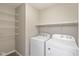 A laundry room with modern appliances and ample shelving for storage at 14446 Chapelwood Ln, Fishers, IN 46037