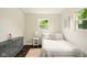 Simple bedroom with hardwood floors, a pastel rug, a dresser and a window at 1513 S Rural St, Indianapolis, IN 46203