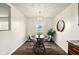 A simple dining room with a round table, four chairs, a modern light fixture, and wood-look floors at 1513 S Rural St, Indianapolis, IN 46203