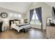 Spacious bedroom with vaulted ceiling features large window with curtains and a stylish clock at 1586 Mairn Ave, Carmel, IN 46032