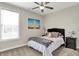 Well-lit bedroom features a ceiling fan, ample natural light, and a large decorative picture at 1586 Mairn Ave, Carmel, IN 46032