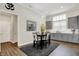 Dining area with a black table and chairs, modern light fixture, and gray cabinets with a white backsplash at 1586 Mairn Ave, Carmel, IN 46032