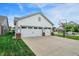 A three-car garage with a basketball hoop on the driveway and manicured green lawn at 1586 Mairn Ave, Carmel, IN 46032