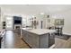 Kitchen island with modern gray cabinetry and quartz countertops overlooks the adjacent dining and living areas at 1586 Mairn Ave, Carmel, IN 46032
