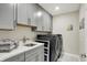 Well-equipped laundry room with modern washer, dryer, and gray cabinets at 1586 Mairn Ave, Carmel, IN 46032