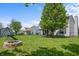 Expansive backyard with a lush lawn, fire pit, and a covered patio area perfect for outdoor entertaining at 1605 Perry Commons Blvd, Indianapolis, IN 46217