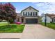 Charming two-story home featuring a brick front, black shutters, two-car garage, and a well-manicured lawn at 1605 Perry Commons Blvd, Indianapolis, IN 46217
