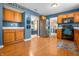 Well-lit kitchen featuring wood cabinets, stainless steel appliances, and a view into an adjacent living room at 1605 Perry Commons Blvd, Indianapolis, IN 46217