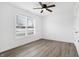 Bright bedroom with a ceiling fan, large window, and stylish gray wood flooring at 1612 Paula Dr, Columbus, IN 47201