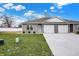 Charming townhouse featuring gray siding, a two-car garage, and a well-manicured lawn at 1612 Paula Dr, Columbus, IN 47201